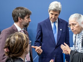 Federal Environment Minister Steven Guilbeault, left, and John Kerry, U.S. Special Presidential Envoy for Climate, speak with other delegates at a meeting of G7 energy ministers in Berlin, Germany, on May 26, 2022.