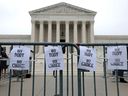 Pro-choice signs hang from a police barricade in the US Supreme Court building in Washington on May 3, 2022, after a draft court decision on abortion rights was leaked to the media.