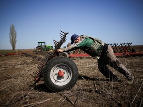 Oleksiy, a Ukrainian farmer, wearing body armour, works at the topsoil in a field, amid Russia's invasion of Ukraine, in Zaporizhzhia region, Ukraine April 26, 2022.