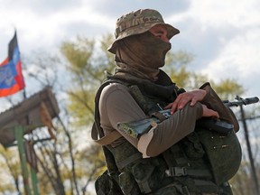 A service member of pro-Russian troops stands guard near a temporary accommodation centre for evacuees during Ukraine-Russia conflict in the village of Bezimenne in the Donetsk Region, Ukraine May 1, 2022.