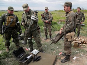 Service members of pro-Russian troops inspect an AT4 anti-tank launcher of the Ukrainian armed forces outside the town of Svitlodarsk, Ukraine, on May 25.