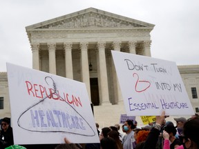 Demonstrators hold up signs during a protest outside the U.S. Supreme Court, after the leak of a draft majority opinion written by Justice Samuel Alito preparing for a majority of the court to overturn the landmark Roe v. Wade abortion rights decision later this year, in Washington, on May 3.