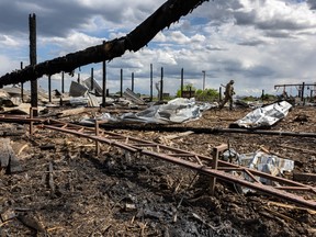 A Ukrainian soldier walks through the grounds of a lumber mill which was rocketed by Russian forces on May 17, 2022 in Zolochiv, Ukraine.