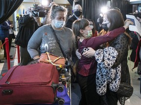Nine-year-old Zoriana, middle, greets her sister, Sofiia, as her and their mother, Natalia, arrive from Ukraine in St. John's, Monday, May 9, 2022. Newfoundland and Labrador received its first plane load of refugees from the Ukraine.
