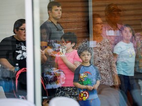 A child looks on through a glass window from inside the Ssgt Willie de Leon Civic Center, where students had been transported from Robb Elementary School after a shooting, in Uvalde, Texas, May 24, 2022.