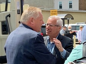 Nipissing PC candidate Vic Fedeli, right, greets Ontario PC Leader Doug Ford in North Bay on May 10, 2022.