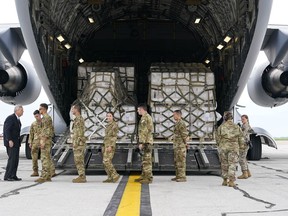 Landwirtschaftsminister Tom Vilsack, links, begrüßt Besatzungsmitglieder einer C-17, die am 22. Mai 2022 auf dem Indianapolis International Airport in Indianapolis eine Flugzeugladung Babynahrung geliefert hat.