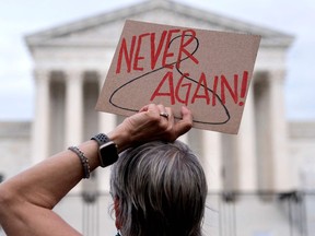 A pro-choice demonstrator holds a sign with a coat hanger, a symbol of the reproductive rights movement on May 11, 2022.