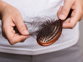 Woman show her brush with long loss hair and looking at her hair.