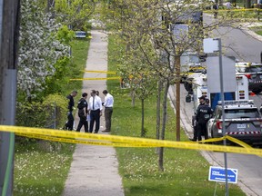 Police and investigators are seen at the scene of a shooting in Toronto, Thursday, May 26, 2022. Toronto police say a man has died after an interaction with officers during which a police gun was fired.