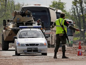 Buses carrying members of Ukrainian forces who have surrendered from the Azovstal steel works in Mariupol drive away under escort of the pro-Russian military on May 17. 2022.