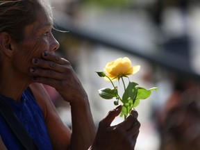 Catherine McCarthy-Martin holds a yellow rose in honour of her niece Chantel Moore during a healing gathering at the B.C. legislature in Victoria on Thursday, June 18, 2020. A jury of three women and two men has been chosen in the coroner's inquest into the death of Chantel Moore -- a 26-year-old Indigenous woman fatally shot by police in Edmundston, N.B., during a wellness check on June 4, 2020.