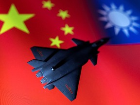 A model of the Chinese Fighter aircraft is seen in front of Chinese and Taiwanese flags in this illustration.