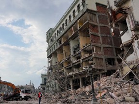 A worker looks on as debris are being removed after an explosion hit the Hotel Saratoga, in Havana, Cuba May 6, 2022.