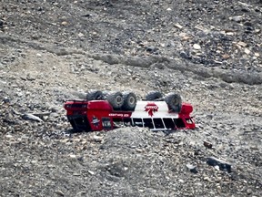 A rolled-over tour bus rests where it fell on the Columbia Icefield near Jasper, Alta., Sunday, July 19, 2020. A tour bus operator has been charged in the deadly crash.THE CANADIAN PRESS/Jeff McIntosh