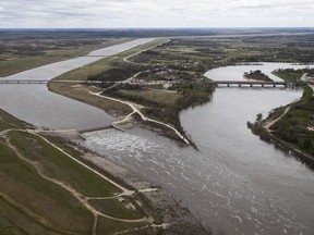 The Winnipeg Floodway outlet, left, and the Red River just north of Winnipeg, Sunday, May 15, 2022. The floodway is used to divert Red River floodwater around the city of Winnipeg. Manitoba is preparing for more rain while cleaning up from flash floods and other destruction caused by an extremely wet spring.