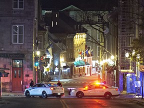 Police cars block St-Louis Street near Le Château Frontenac, early Sunday, Nov. 1, 2020, in Quebec City, where a man wearing medieval clothes was arrested. Jurors are deliberating for a second day at the first-degree murder of the Halloween stabbing suspect. Carl Girouard, 26, is charged with two counts of first-degree murder in the deaths of François Duchesne, 56, and Suzanne Clermont, 61. He is also charged with five counts of attempted murder in the attack.