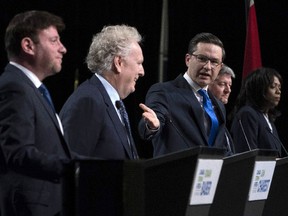 Conservative leadership candidate Pierre Poilievre, centre, gestures towards Jean Charest, as Roman Baber, left, Scott Aitchison and Leslyn Lewis, right, debate at the Canada Strong and Free Network conference in Ottawa, on May 5.