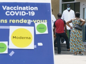 People are screened as they enter a COVID-19 vaccination clinic in Montreal, on Thursday, July 22, 2021.
