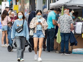 Shoppers wear face masks on Montreal's Ste-Catherine Street in a file photo from Sept. 12, 2021. Quebec's mask mandate is ending May 14.