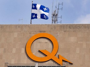 A Hydro-Québec logo is seen on their head office building in Montreal, Thursday, Feb. 26, 2015. Hydro-Québec says more than 130,000 customers are still without power after a powerful storm swept across the province on Saturday.