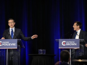 Conservative leadership hopefuls Pierre Poilievre, left, and Patrick Brown share an exchange during the Conservative Party of Canada French-language leadership debate in Laval, Quebec on Wednesday, May 25, 2022.