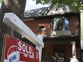 A house with a for sale sign indicating it was sold as seen in Toronto, ON Tuesday, June 23, 2015.