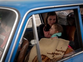 A family fleeing Russian-occupied Tokmak, Ukraine, is registered at a reception center in Zaporizhzhia, where a steady stream of vehicles carrying displaced civilians arrived Monday.
