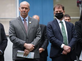 B.C. Premier John Horgan, left, and Health Minister Adrian Dix listen during an announcement to mark the start of construction on the redevelopment and modernization of the Burnaby Hospital, in Burnaby, B.C., on Monday, May 30, 2022.