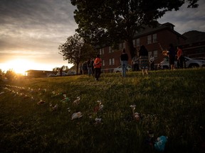 A group of youths lead a group drumming and singing at sunset outside the former Kamloops Indian Residential School, to honour the lives of those suspected to be buried in unmarked graves near the facility, in Kamloops, B.C., on Friday, June 4, 2021.