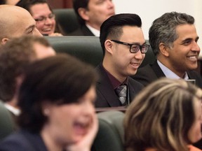 Thomas Dang (centre) laughs along with his colleagues during an introductory meeting with newly elected NDP MLAs in Edmonton on May 12, 2015.