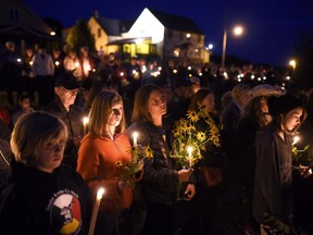 Mourners hold a candlelight vigil in remembrance of Carol Culleton, Anastasia Kuzyk and Natalie Warmardam in Wilno, Ont. on Friday, Sept. 25, 2015.&ampnbsp;A coroner's inquest has heard from a former Victim/Witness Assistance Program manager who worked with two of three women killed by their former partner in eastern Ontario. THE&ampnbsp;CANADIAN PRESS/Justin Tang