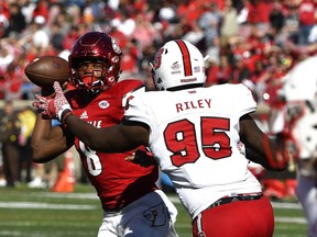 Louisville's Lamar Jackson (8) attempts to avoid the pass rush of North Carolina State's Tyrone Riley (95) during the second half of their NCAA college football game, Saturday, Oct. 22, 2016, in Louisville, Ky. Louisville won 54-13. In the space of a week, American rookie offensive lineman Tyrone Riley has gone from the Hamilton Tiger-Cat's practice roster to the starting lineup.&ampnbsp;&ampnbsp;