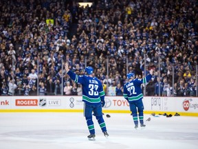 Vancouver Canucks' Henrik Sedin, left, and his twin brother Daniel Sedin, both of Sweden, wave to the crowd after defeating the Arizona Coyotes 4-3 in their last home NHL hockey game, in Vancouver on Thursday, April 5, 2018.
