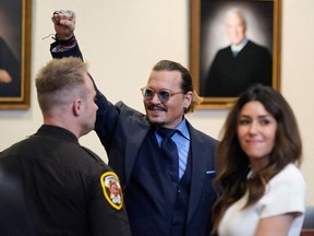 Actor Johnny Depp gestures to spectators in court after closing arguments at the Fairfax County Circuit Courthouse in Fairfax, Virginia, on May 27, 2022.
