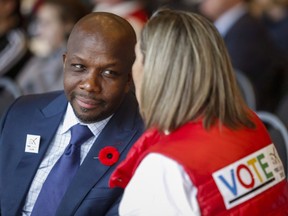 Former Olympian Donovan Bailey, left, speaks to a fan during a rally in support of the 2026 Winter Olympic bid in Calgary, Alta., Monday, Nov. 5, 2018. Bailey is among the dozens of performers, athletes, advocates and experts newly named to the Order of Canada on Wednesday.