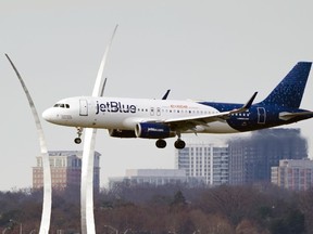 A JetBlue passenger flight passes the Air Force Memorial as it prepares to land at Reagan Washington National Airport in Arlington, Va., across the Potomac River from Washington, Wed., Jan. 19, 2022. U.S. airline JetBlue launched its service to Canada with the first flight arriving in this evening in Vancouver from New York's JFK International Airport.
