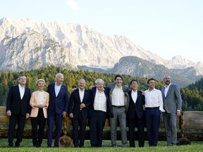 Members of the G7 from left, Prime Minister of Italy Mario Draghi, European Commission President Ursula von der Leyen, President Joe Biden, German Chancellor Olaf Scholz, British Prime Minister Boris Johnson, Canadian Prime Minister Justin Trudeau, Prime Minister of Japan Fumio Kishida, French President Emmanuel Macron and European Council President Charles Michel stand for a photo at Schloss Elmau following their dinner at G7 Summit in Elmau, Germany, Sunday, June 26, 2022. The bench behind them became famous when former German Chancellor Angela Merkel and former President Barack Obama were photographed talking by it.