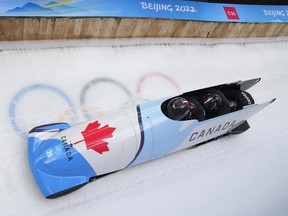 Justin Kripps of Canada and his team drive their 4-man bobsled during a training heat at the 2022 Winter Olympics in Beijing, Wednesday, Feb. 16, 2022. Canadian bobsled and skeleton athletes fear their national federation is trying to silence them, saying a clause in their athlete agreement contradicts the principles of safe sport.