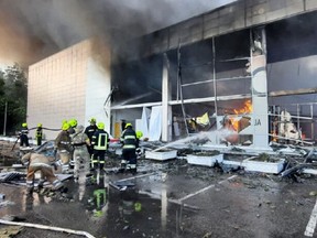 This handout picture taken and released by the Ukraine's State Emergency Service on June 27, 2022 shows firefighters putting out the fire in a mall hit by a Russian missile strike in the eastern Ukrainian city of Kremenchuk, killing at least two and injuring dozens more, Ukraine's President said.