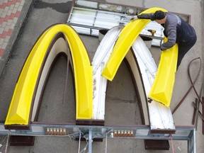 A worker dismantles the McDonald's Golden Arches while removing the logo signage from a drive-through restaurant of McDonald's in the town of Kingisepp in the Leningrad region, Russia June 8, 2022.