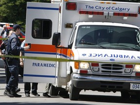 Police surround an ambulance in Calgary on May 28, 2008. Alberta Health Services says it is investigating why it took 30 minutes for an ambulance to respond after dogs attacked an 86-year-old woman in Calgary.