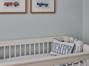 The nursery is blue and white and traditionally styled.