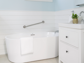 The bathroom has grab bars and includes a luxurious standalone tub and shower.