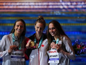Summer McIntosh, center, of Canada, second placed Katie Grimes of the United States, left, and third placed Emma Weyant of the United States celebrate after the women's 50m freestyle final at the 19th FINA World Championships in Budapest, Hungary, Saturday, June 25, 2022.&nbsp;McIntosh became the first Canadian to win two gold medals at a FINA world championships on Saturday with a victory in the women's 400-metre individual medley.