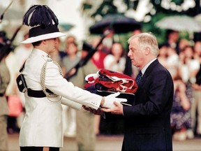 Chris Patten, right, the 28th and last governor of colonial Hong Kong, receives the Union Jack flag after it was lowered for the last time at Government House, during a farewell ceremony in Hong Kong, on June 30, 1997.