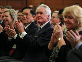 Sen. Victor Oh, second from left, listens as Prime Minister Stephen Harper speaks to his national caucus in Ottawa in 2013.