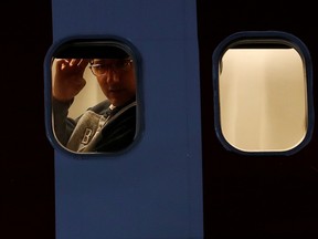 Prime Minister Justin Trudeau closes the shutter of his window on board a flight departing from Winnipeg in 2019.