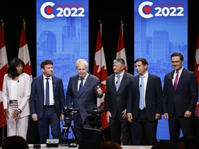 Candidates, left to right, Leslyn Lewis, Roman Baber, Jean Charest, Scott Aitchison, Patrick Brown, and Pierre Poilievre stand onstage following the Conservative Party of Canada English leadership debate in Edmonton, May 11, 2022.