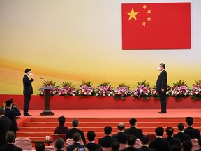 China's President Xi Jinping, right, watches as Hong Kong's incoming Chief Executive John Lee is sworn in during a ceremony to inaugurate the city's new government, in Hong Kong on July 1, 2022.